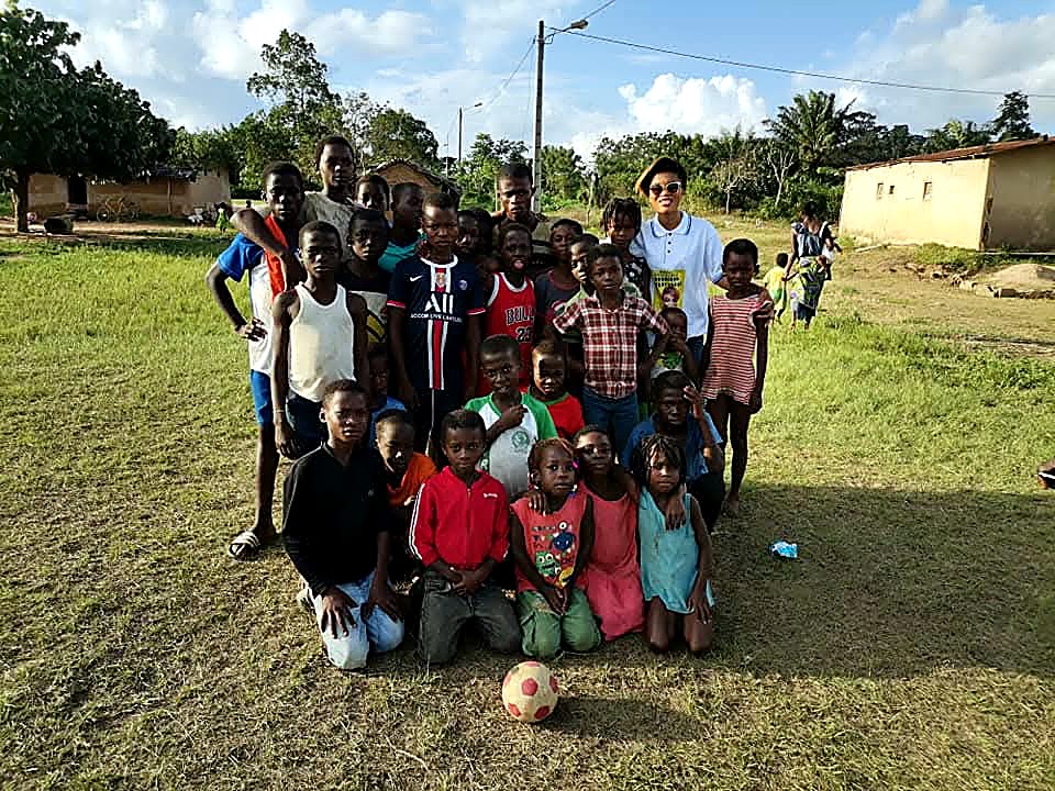 Enfants réunis autour d'un ballon lors d'un tournoi de football au village