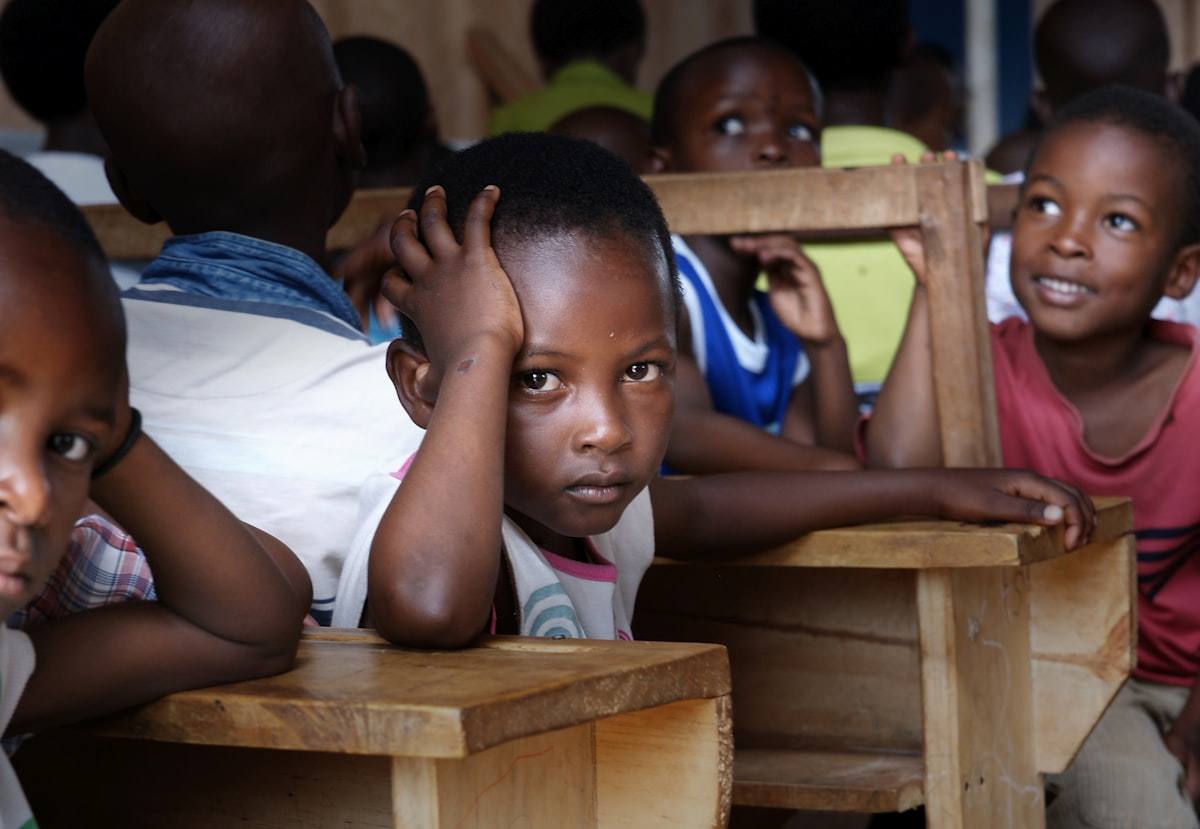 Écoliers souriants assis à leurs pupitres