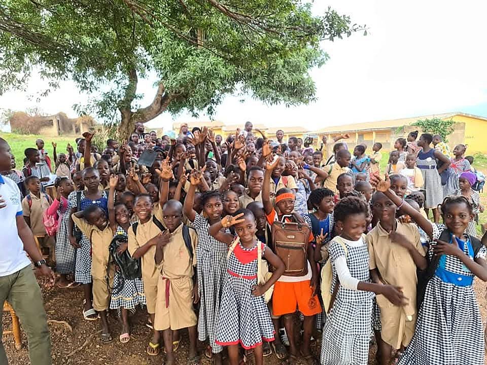 Élèves en uniforme rassemblés joyeusement devant leur école