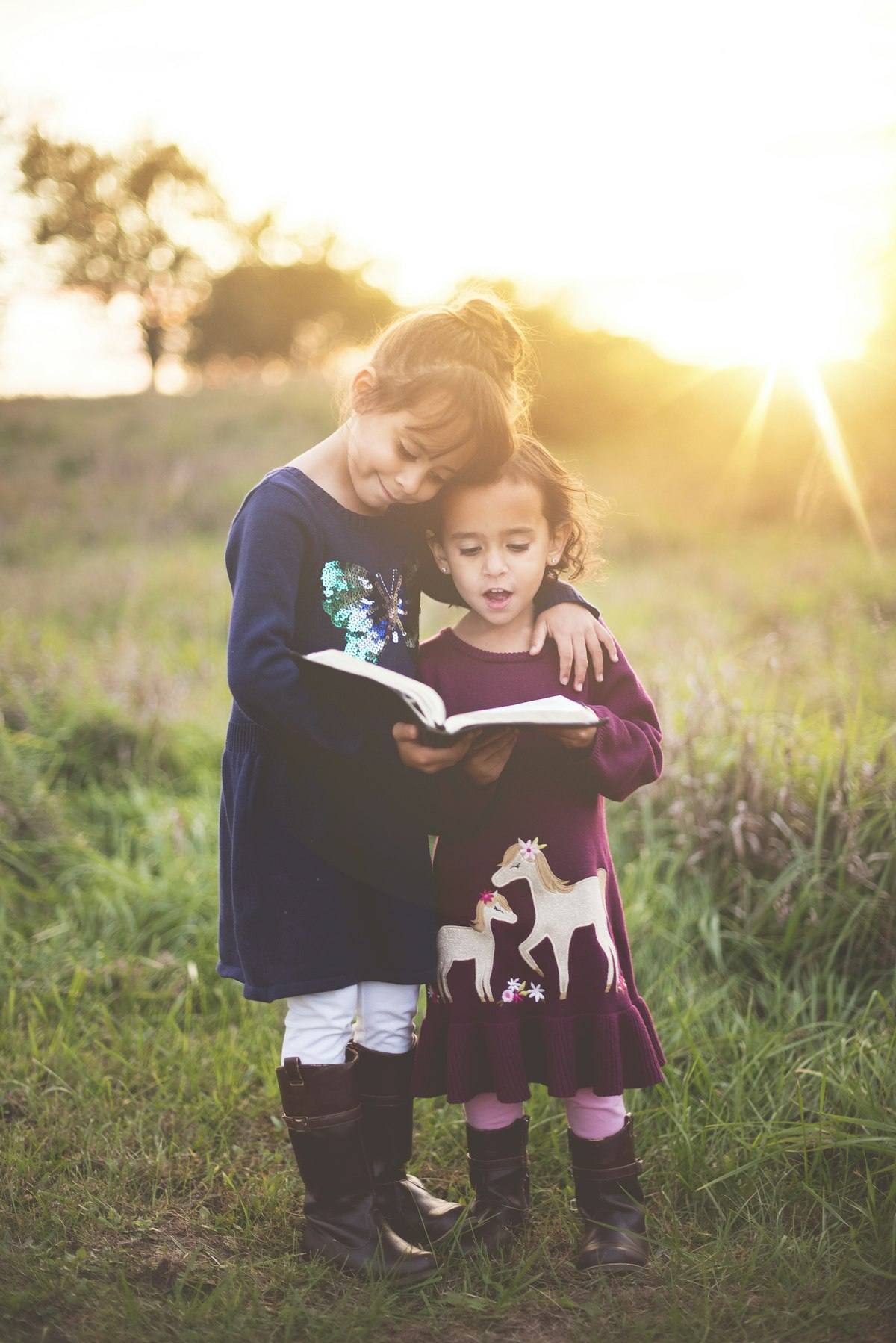 Une mère lit un livre à son enfant au coucher du soleil
