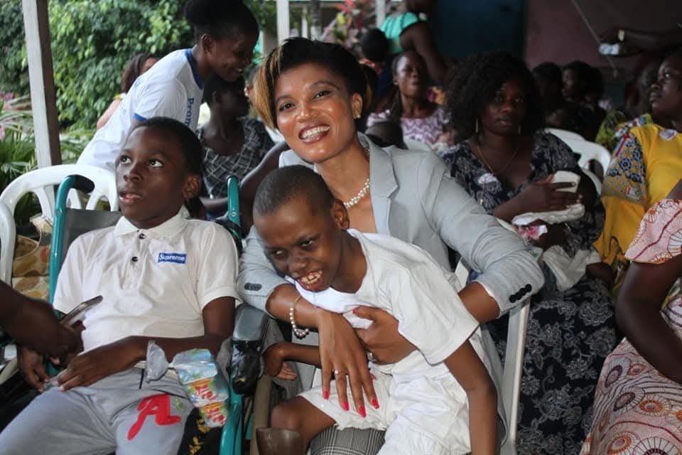 La présidente de la Fondation auprès d'un enfant atteint d'Infirmité Motrice Cérébrale, lors d'une action de soutien à Abidjan